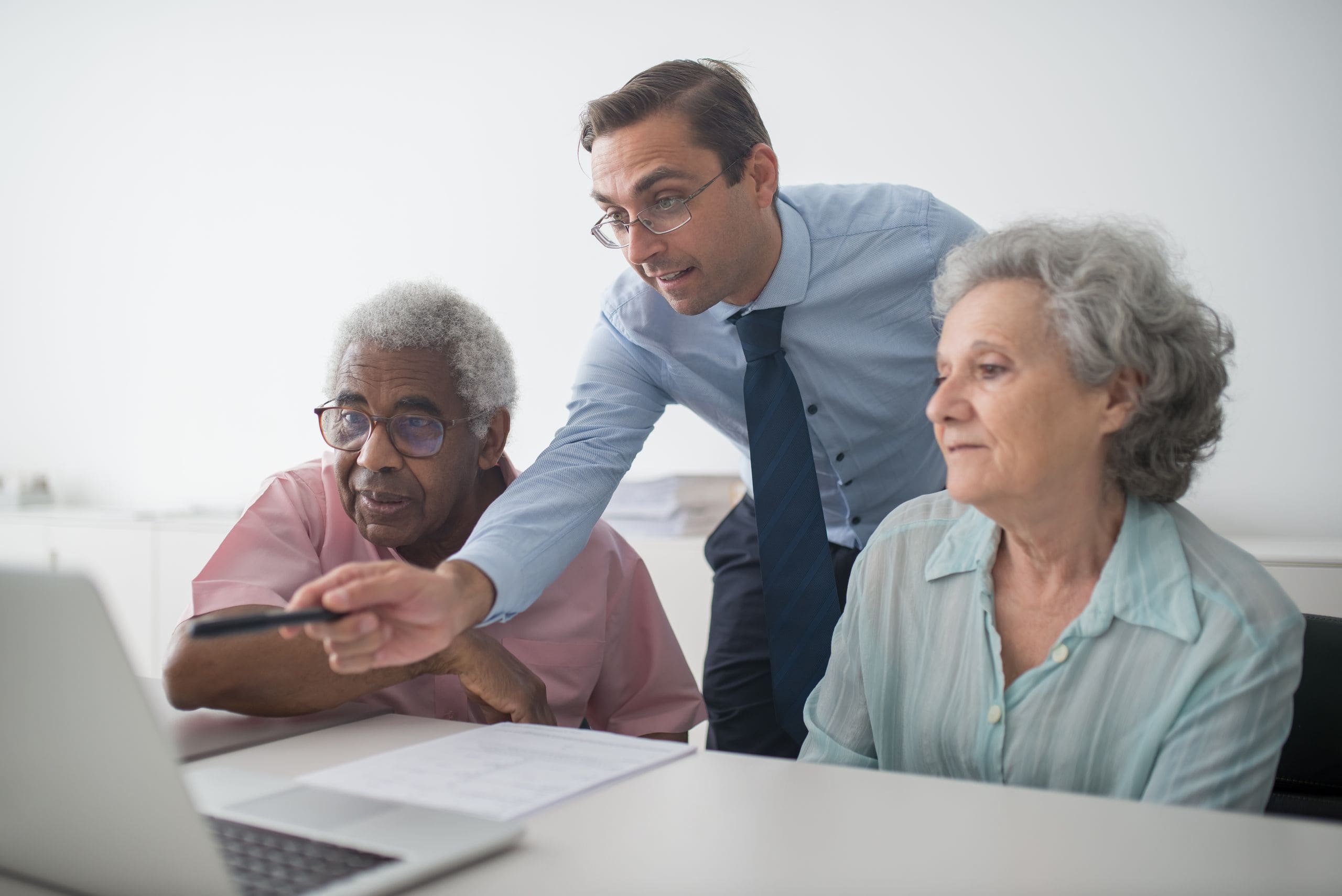 A senior JULY leader mentoring a younger colleague over a laptop in a warm Vancouver office