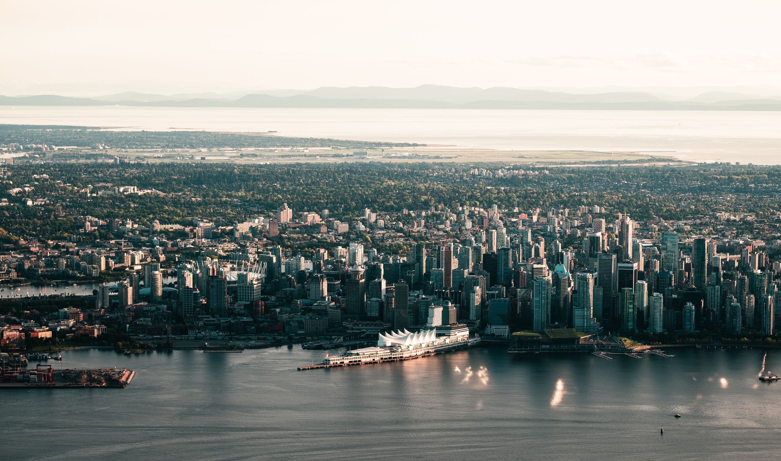 Friends and families of many nationalities taking in the Vancouver skyline together from a sunlit lookout